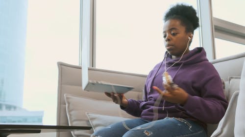 一个坐在沙发上的女人在笔记本电脑上工作时正在吃糖果 · 免费素材视频