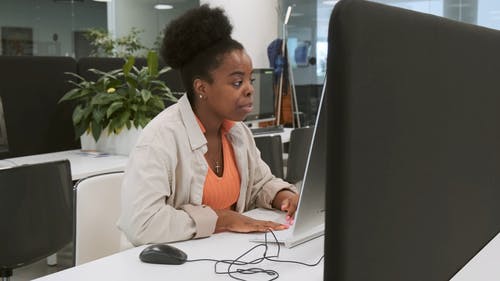 一个坐在椅子上的女人在办公室的计算机上工作 · 免费素材视频