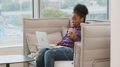 一个女人在她身上工作时嚼着糖果：Laptop · 免费素材视频