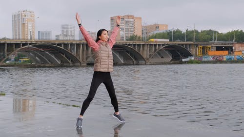 一名女子在河岸边做跳跃运动 · 免费素材视频