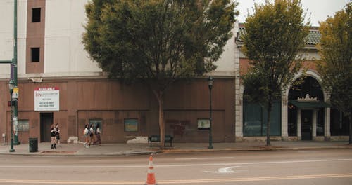 车辆经过时在城市街道的人行道上行走的人的慢动作镜头 · 免费素材视频