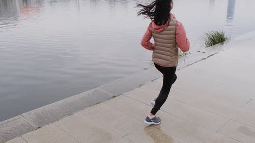 一个女人在河边慢跑 · 免费素材视频