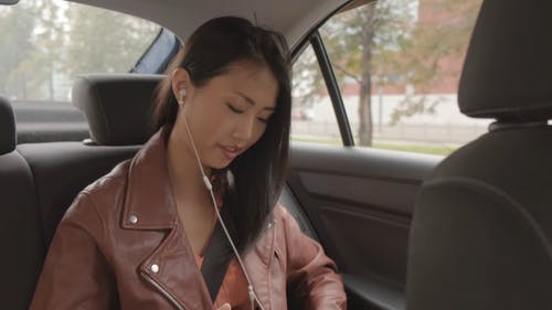 女人在车内听音乐带着耳机 · 免费素材视频