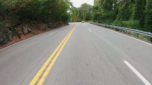 骑自行车的人穿越建在山坡上的道路 · 免费素材视频