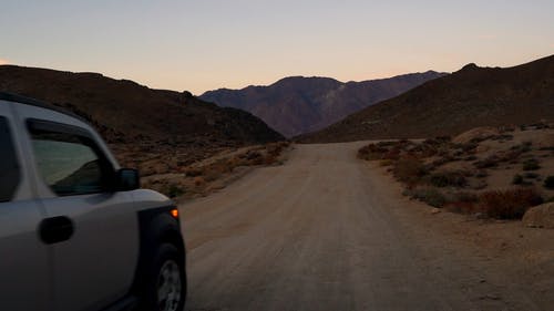 孤独的车辆，在山上行驶在沙漠中的未铺路 · 免费素材视频