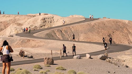 慢动作镜头的人在夏天穿下去丘陵铺成的道路 · 免费素材视频