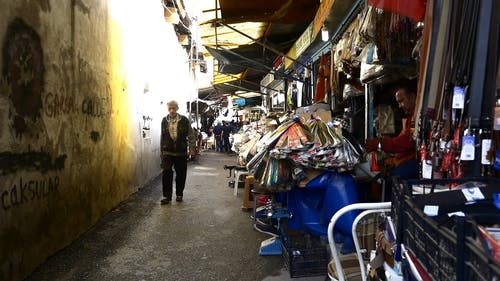 人们走在一条小巷，两旁都是卖小商品的小企业 · 免费素材视频