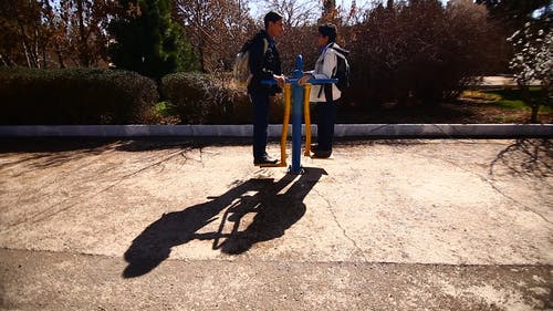 两个男孩骑在公园的秋千上 · 免费素材视频