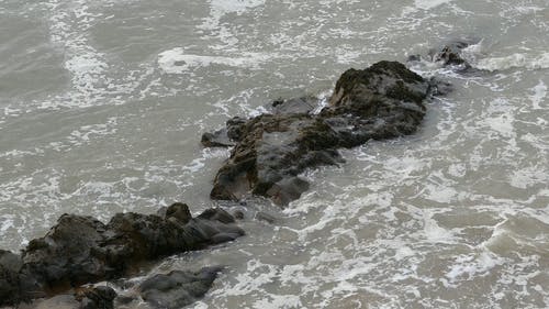 海浪冲撞到海边的岩石形成 · 免费素材视频