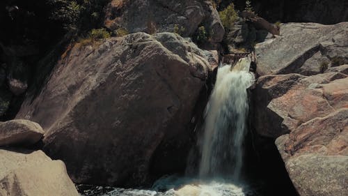 瀑布穿过岩层 · 免费素材视频