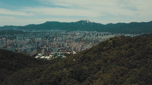 一对夫妇从山上的岩石欣赏城市风景 · 免费素材视频