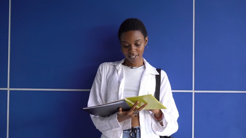 一个女人站在蓝色的墙前 · 免费素材视频