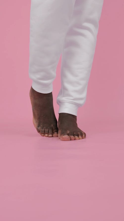 有关垂直视频, 白色的裤子, 粉红色背景的免费素材视频