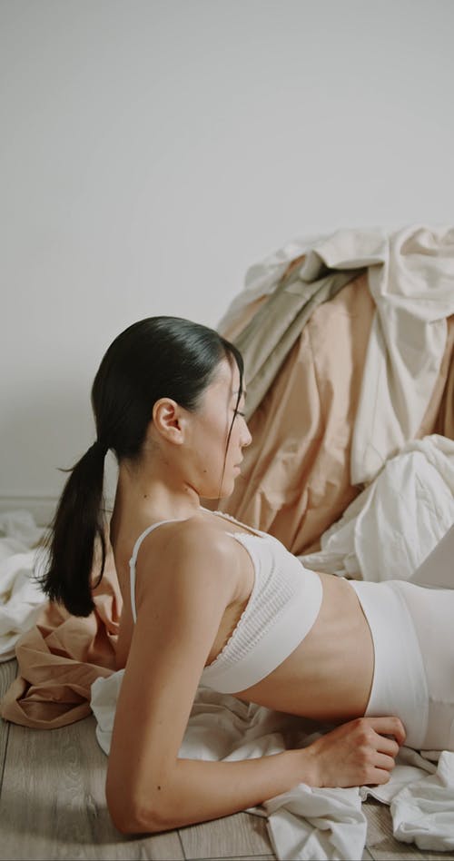 坐在一堆衣服旁边的女人 · 免费素材视频