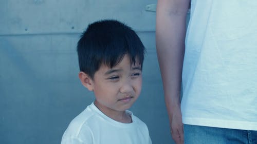 站在他父母旁边的白色上衣的可爱男孩 · 免费素材视频