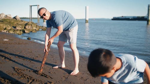 爸爸和儿子在沙滩上写字 · 免费素材视频
