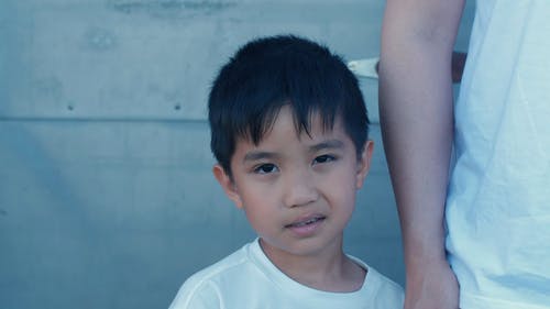 站在他父母旁边的白色上衣的可爱男孩 · 免费素材视频