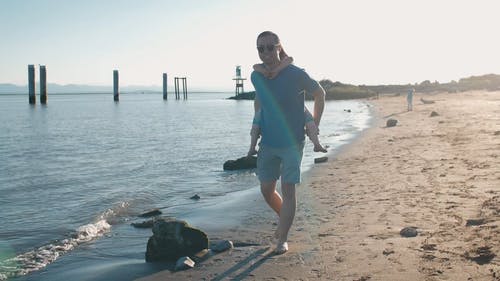 爸爸背着可爱的女儿在沙滩上散步 · 免费素材视频