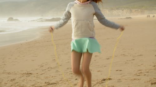 在海滩上做跳绳的女孩 · 免费素材视频