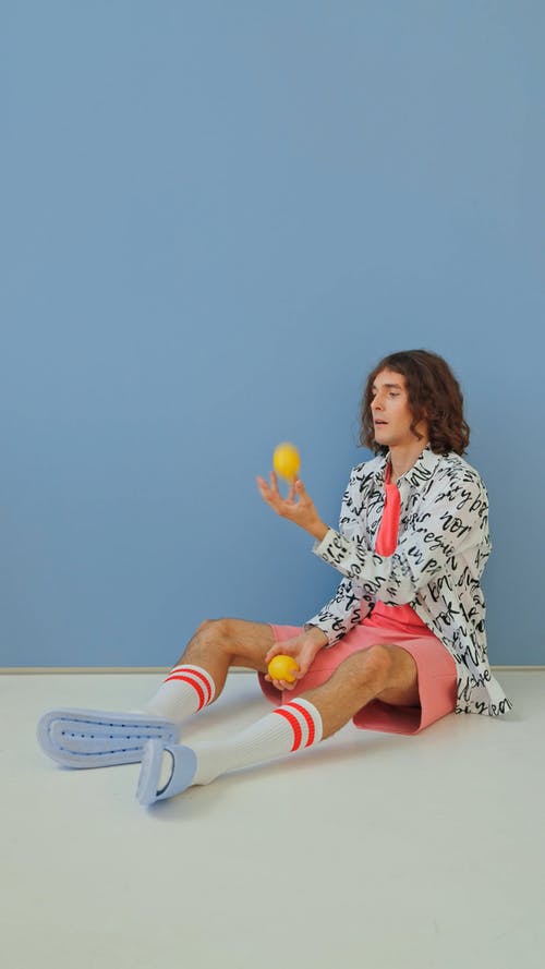 一个男人坐在地板上玩柠檬 · 免费素材视频