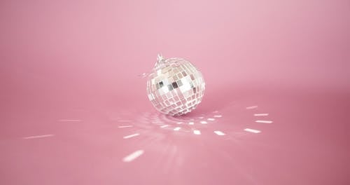在粉红色的表面反射方形光反射的小镜子球 · 免费素材视频