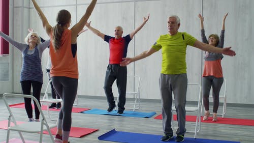 一位女健身教练教老人组一些适合他们的运动 · 免费素材视频