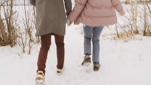 幸福的夫妻在雪中运行 · 免费素材视频