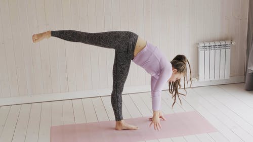 一个女人在垫子上做伸展运动和平衡运动 · 免费素材视频