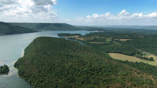 树木和群山环抱的一个湖的航拍画面 · 免费素材视频