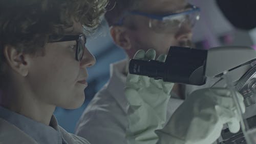 通过显微镜看科学的女人 · 免费素材视频