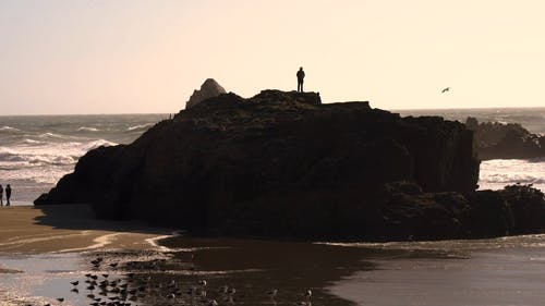 一个人操作无人机站在石山上 · 免费素材视频