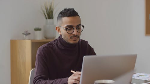在他的电脑打字前戴眼镜的人 · 免费素材视频
