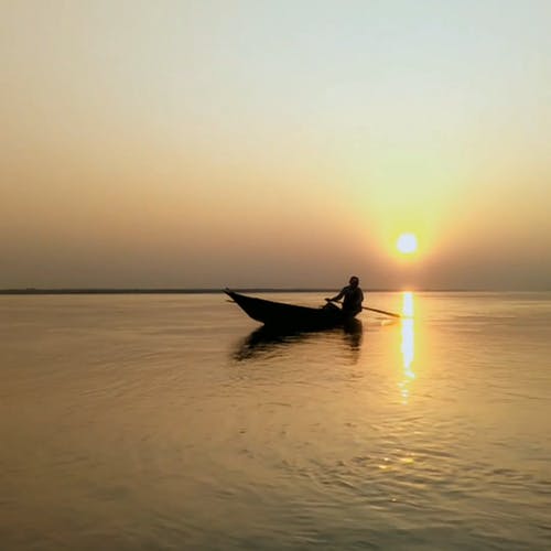 一个男人在一条船在日落时的剪影 · 免费素材视频