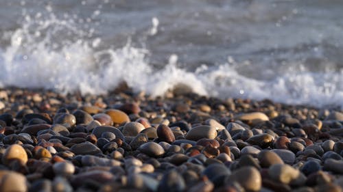 海浪冲刷海岸线上的碎石 · 免费素材视频