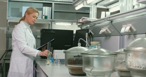 一名妇女在实验室检查试管中的液体样品 · 免费素材视频