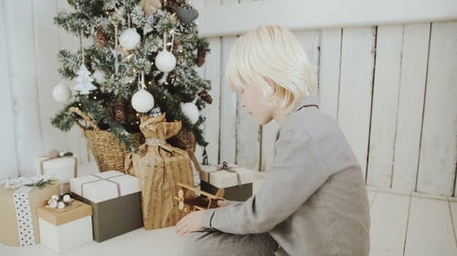 一个男孩在圣诞树旁玩他的飞机玩具 · 免费素材视频