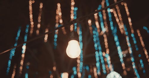 灯泡和圣诞灯照亮了夜晚的黑暗 · 免费素材视频