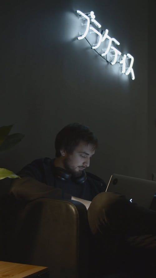 笔记本电脑上的一个人戴上耳机 · 免费素材视频