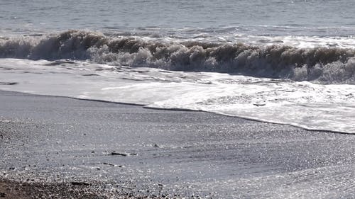 海浪亲吻海滩岸边光滑的沙滩 · 免费素材视频