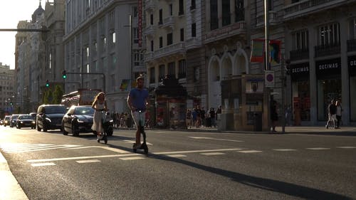一个男人和一个女人在街上使用电动手推车 · 免费素材视频