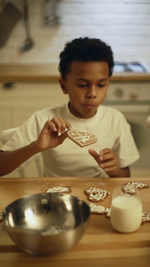 一个男孩在吃饼干之前蘸一杯牛奶中的饼干 · 免费素材视频