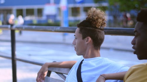 两个年轻人坐在长椅上聊天 · 免费素材视频