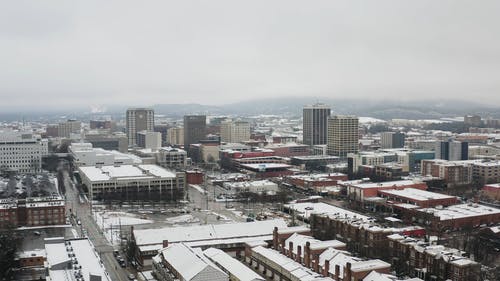 冬季城市建筑物的雪覆盖屋顶的无人机画面 · 免费素材视频