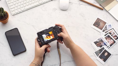 一个人检查在现代数码相机中拍摄和存储的照片 · 免费素材视频