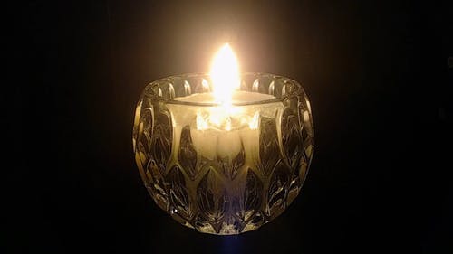 在黑暗中发光的燃烧的蜡烛的特写镜头 · 免费素材视频