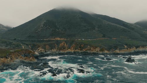 在水体附近的一座山脚下的路 · 免费素材视频