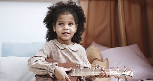 一个年轻的女孩在演奏ukelele · 免费素材视频