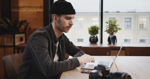 在他的笔记本电脑上工作的咖啡店里的男人 · 免费素材视频