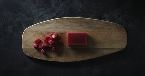 将寿司刀和金枪鱼丁和肉一起放在木砧板上 · 免费素材视频