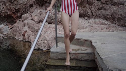 条纹泳衣的女人走向天然泉水 · 免费素材视频